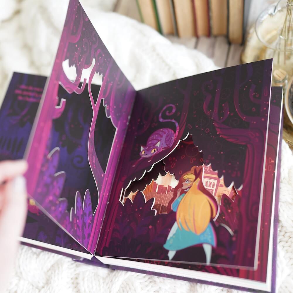 A three-page papercut spread - Alice walking through wonderland