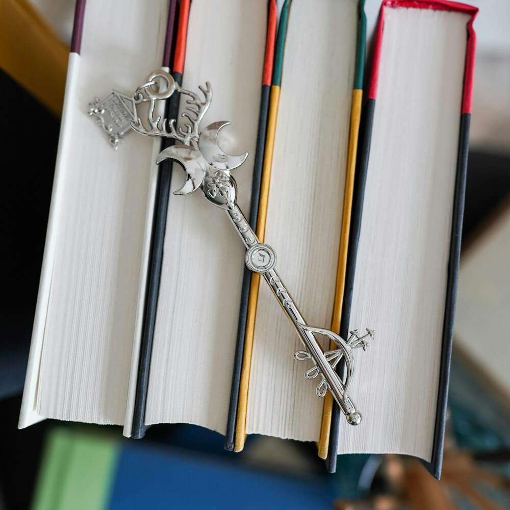 Silver Artemis Greek Mythology Key has a bow and arrow, crescent moons, antlers, and a bee.