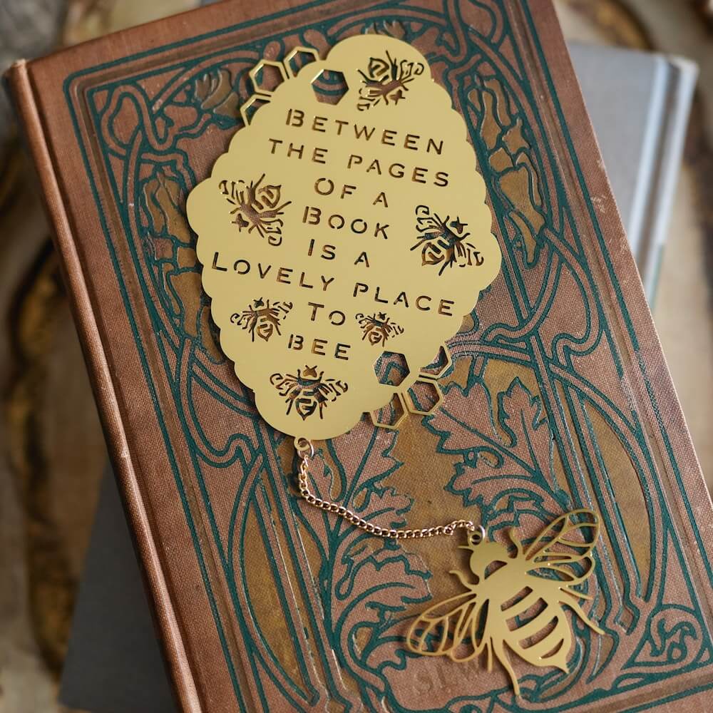 metal beehive bookmark with bees that says "Between the pages of a book is a lovely place to bee"