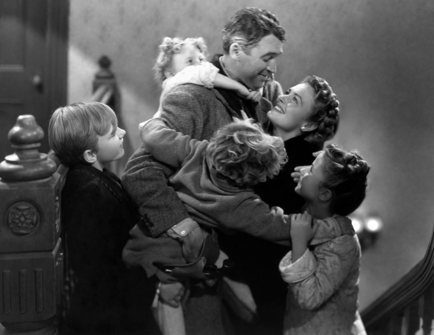 a black and white image of the Bailey family by a Christmas tree from the 1946 It's a Wonderful Life