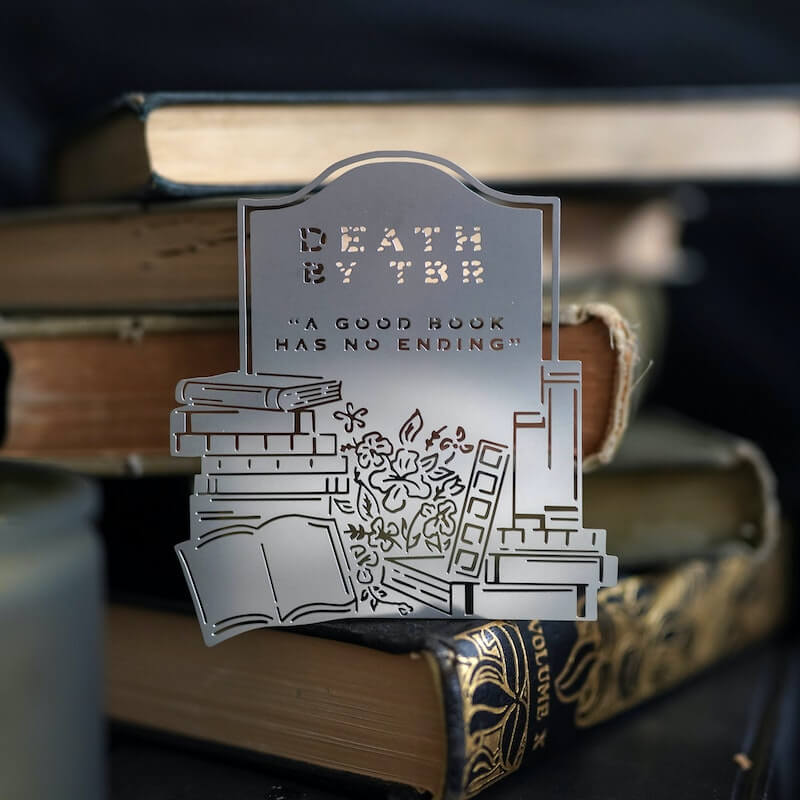 Death by TBR Metal Bookmark looks like tombstone and reads "Death by TBR 'A good book has no ending'"