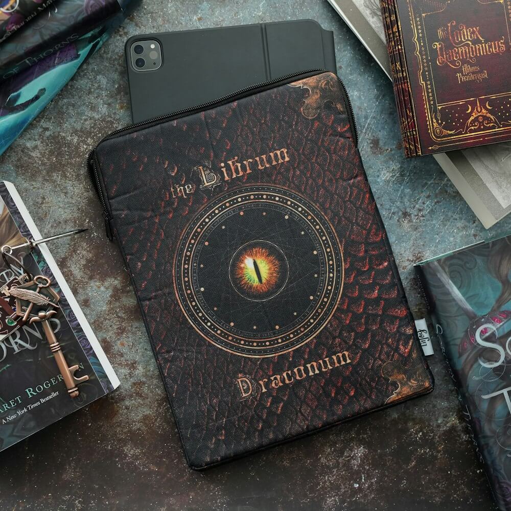 Grimoire Book Sleeve has dragon scale print, magical designs, "The Librum Draconum," and author's name "Margaret Rogerson"