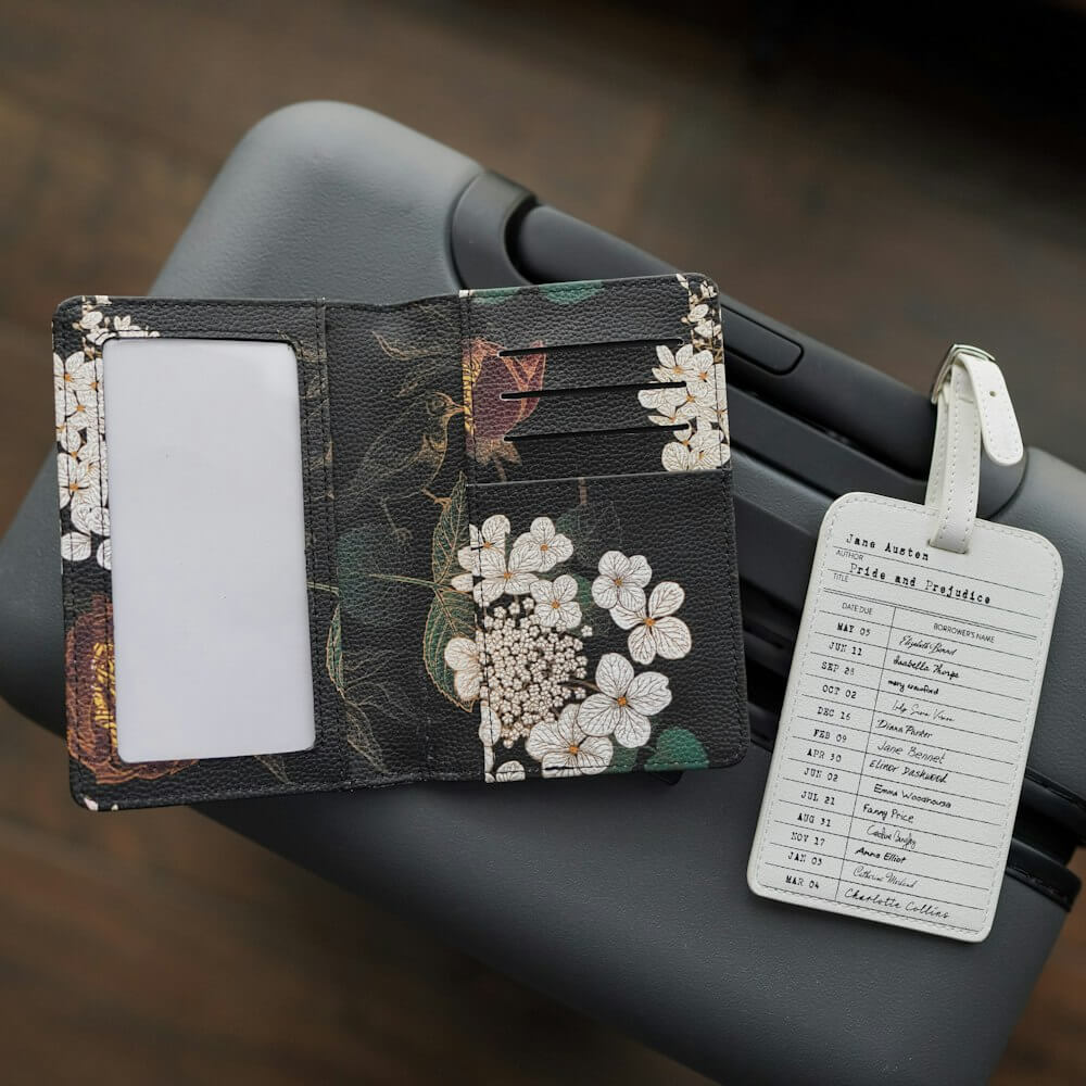 Passport featuring Regency-era florals reads "Pride and Prejudice" and a library card luggage tag including character names