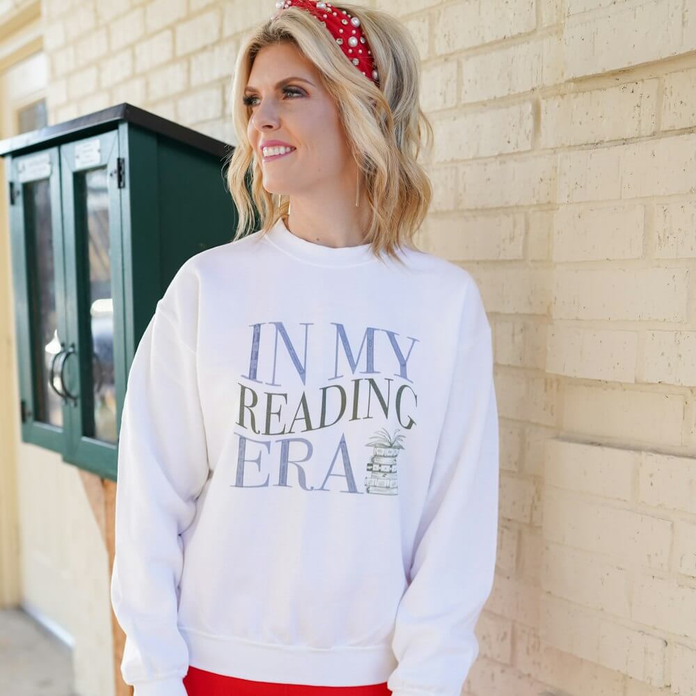 Blonde woman wearing white In My Reading Era sweatshirt