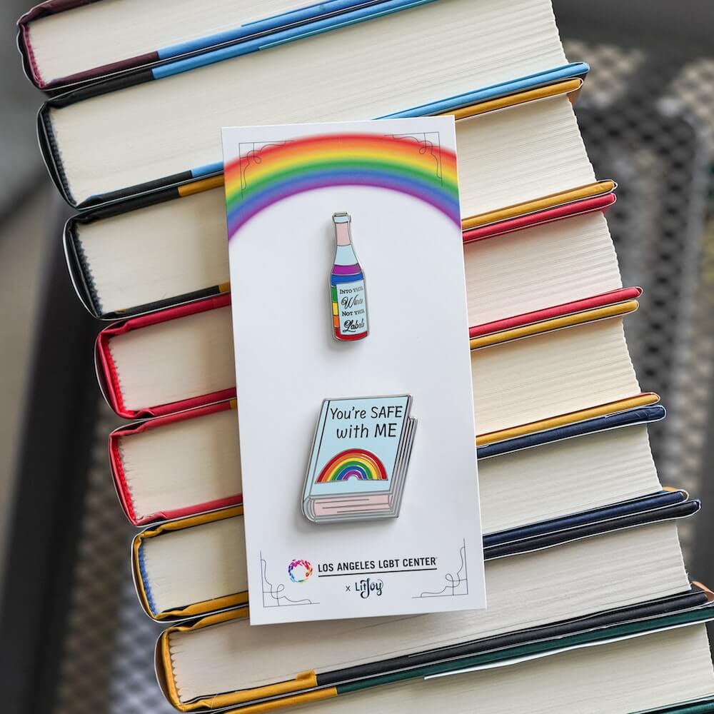 Pride Pin Set #2: Rainbow wine bottle "Into the wine, not the label" and book with rainbow that "You're SAFE with ME"
