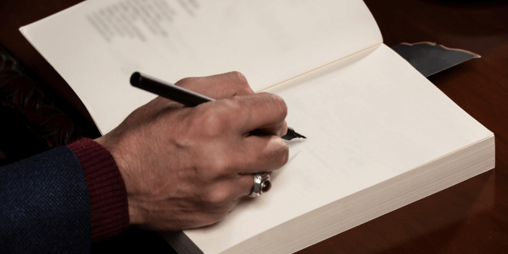 Author signing a book at a book convention