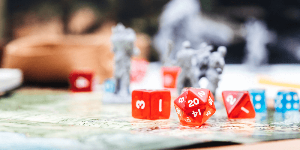 dungeons and dragons die and players sitting on a map