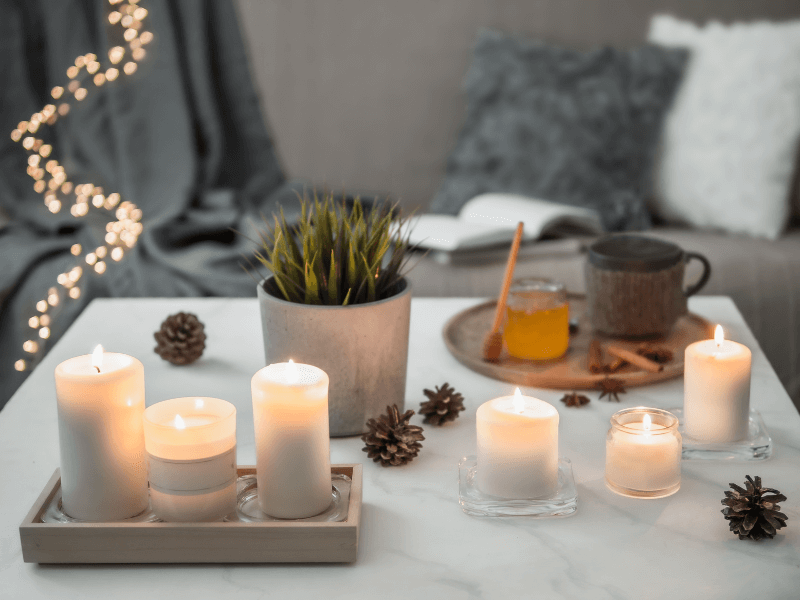 hygge - couch, blankets, book, candles, twinkle lights, tea and honey