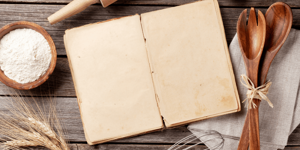 old blank book surrounded by baking materials