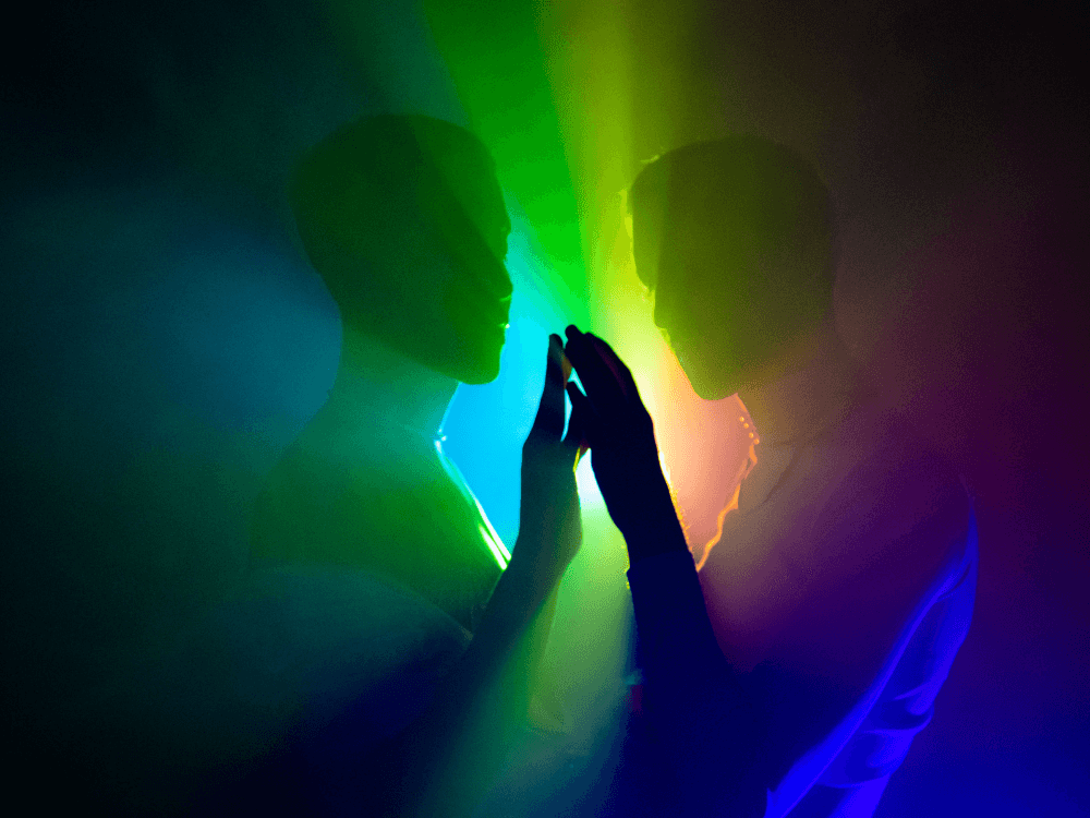 Two people face to face touching hands