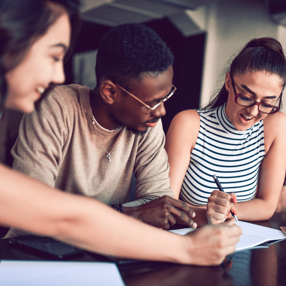 two women and one man studying together