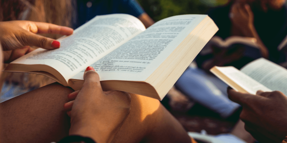 Woman reading a book with friends in their book club